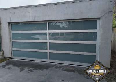 This New Contemporary Glass Aluminum Garage Door was installed in Laguna Beach Ca by Golden Rule Garage Door Inc.