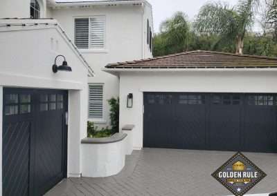 New Custom Wood Carriage House Garage Door installed in San Clemente CA by Golden Rule Garage Door Inc. Black, chevron pattern, paint-grade with windows.