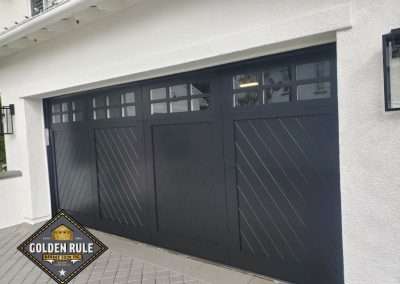 New Custom Wood Garage Door installed in San Clemente CA by Golden Rule Garage Door Inc. Black, chevron pattern, paint-grade with windows.
