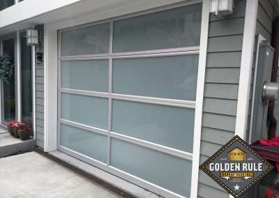 This New Contemporary Glass Aluminum Garage Door was installed in Laguna Beach Ca by Golden Rule Garage Door Inc.