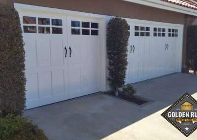 New Custom Wood Carriage House Garage Doors installed in Laguna Niguel CA by Golden Rule Garage Door Inc. White, cape cod style, paint-grade with windows.