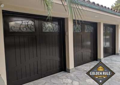 New Custom Wood Carriage House Garage Doors installed in Laguna Niguel CA by Golden Rule Garage Door Inc. Tuscan Paint-Grade with Wrought Iron Windows