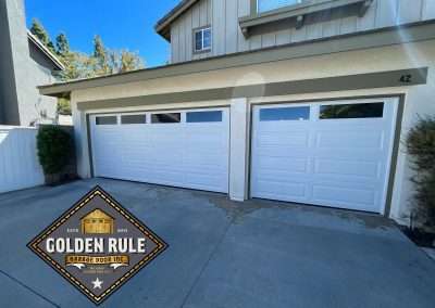These Unique Traditional Long Panel New Garage Doors in White with L100 windows with were installed in Orange County CA by Golden Rule Garage Door Inc.