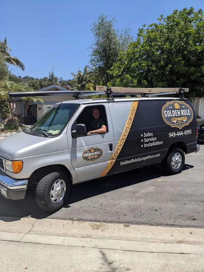Technician in a Golden Rule Garage Door Inc. service van, ready for a garage door repair visit