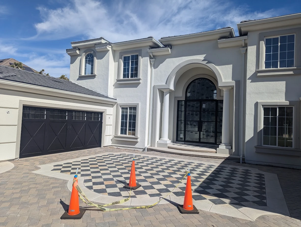 Large home driveway with orange cones set up for garage door service