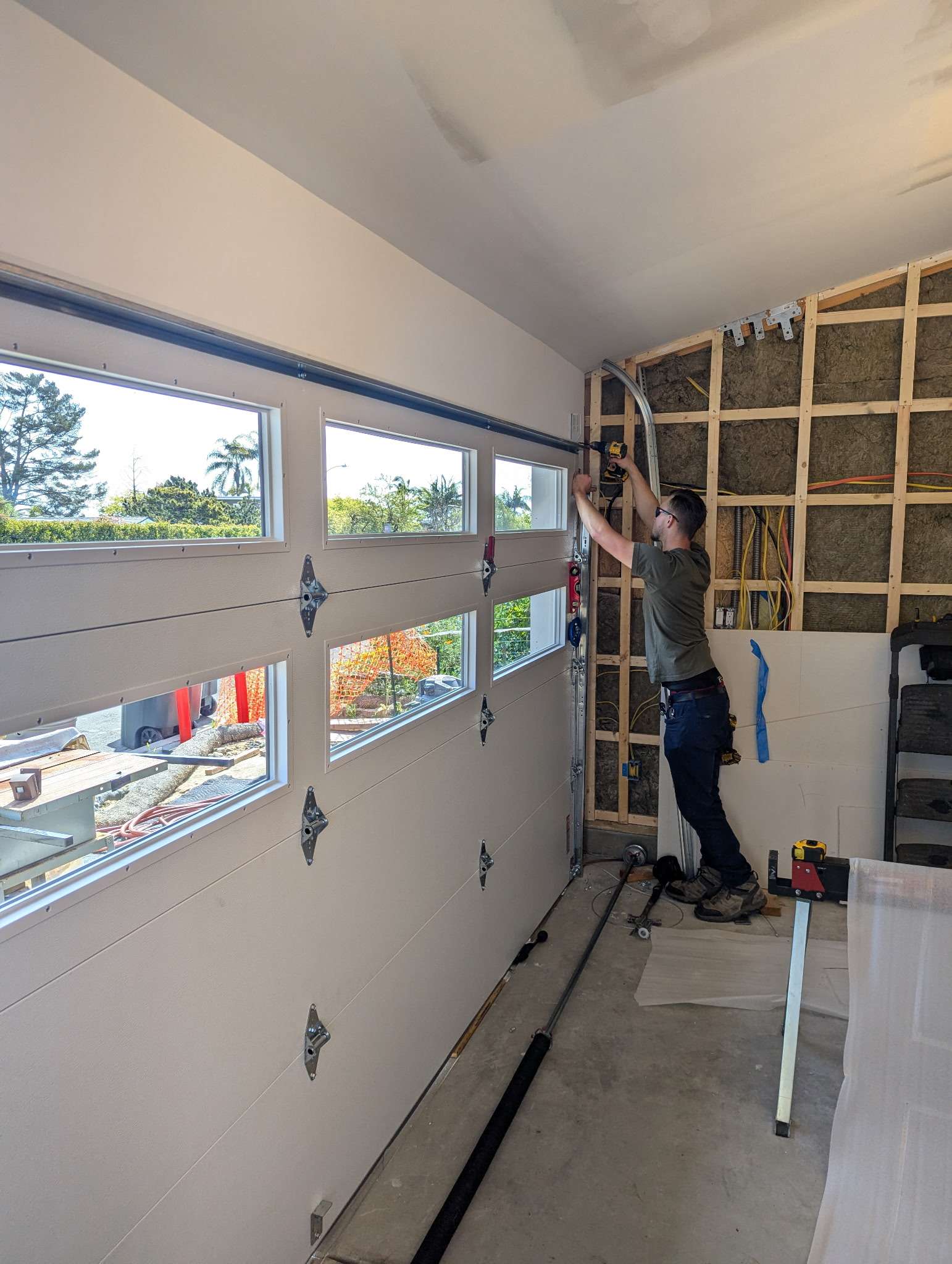 garage-door-maintenance-Orange-County-2 Garage door tune-up in progress with the door open and tools nearby