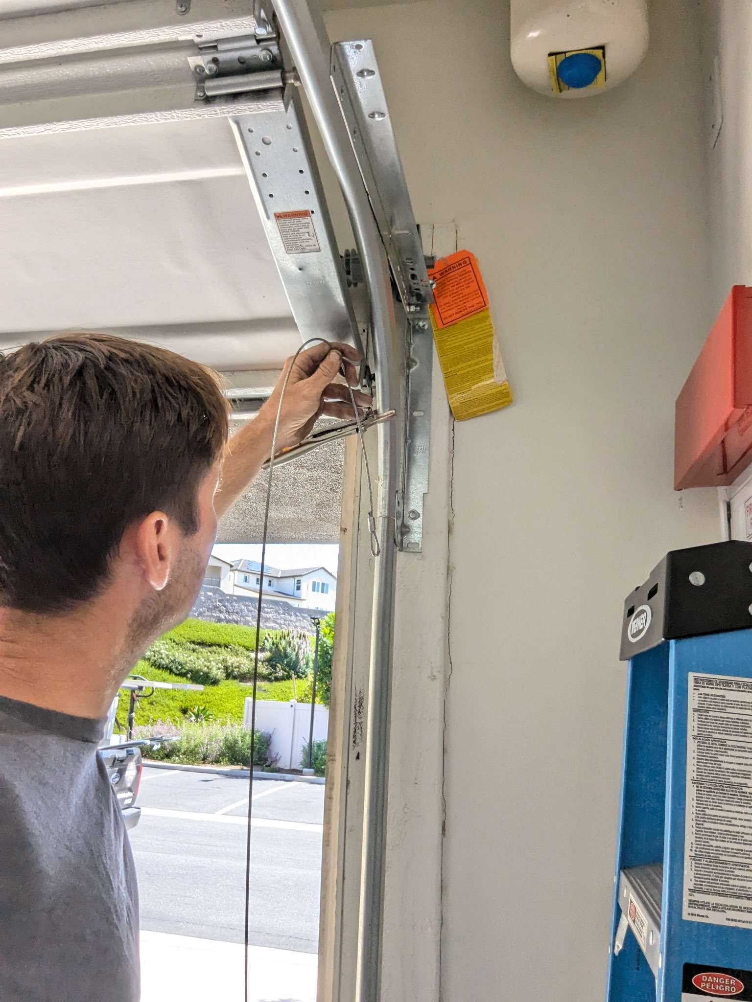 Golden Rule Garage Door Inc. technician adjusting garage door track hardware in Orange County.